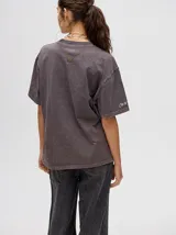 Remerón oversize de algodón, corte cuadrado y básico, color gris oscuro con efecto gastado. Estampa frontal de una figura abstracta o mano en tonos claros y texto en un idioma asiático en la manga.