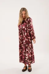Vestido midi con estampado animal print en tonos borgoña y beige, con escote redondo y abertura en el pecho que se ajusta con lazos finos. De silueta relajada, manga larga tipo globo con terminación fruncida y falda amplia con recortes.