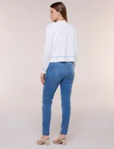Cardigan de punto fino color blanco, con detalles de bordados florales en tono celeste, mangas largas y frente abierto con ribetes celestes.