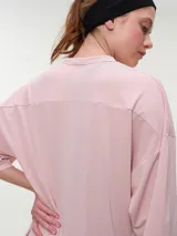 Remera deportiva de manga corta rosada, con escote en V y corte oversized de tejido dry fit.