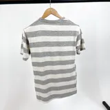 Remera de algodón a rayas horizontales grises y blancas, con logo bordado en el pecho.