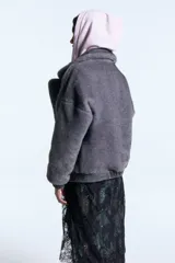 Campera reversible de denim azul con interior de piel sintética marrón. Presenta cuello solapa amplio, cierre frontal con botones metálicos, bolsillos con solapa y puños elásticos.