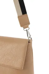 Bandolera de cuero sintético negro con solapa frontal y herrajes plateados. Incluye una correa ajustable y extraíble con diseño de rayas en tonos beige y negro.