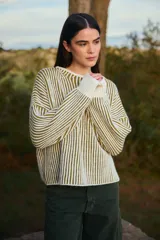 Sweater de punto con diseño de rayas verticales en color crudo y verde oliva, de corte holgado, cuello redondo y mangas largas con puños ajustados.