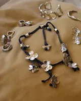 Anillo de diseño artesanal con estructura entrelazada de líneas irregulares y acabado orgánico. Pieza ajustable fabricada en metales nobles.