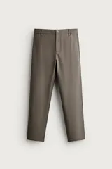 Pantalón slim fit de color marrón grisáceo, con cintura elástica en los laterales, trabillas para cinturón y cierre frontal con botón y cremallera.