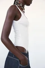 Body negro de escote redondo y tirantes anchos. Cierre inferior con botones a presión. Tejido de punto acanalado.