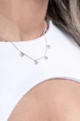 Minivestido blanco ajustado al cuerpo, con cuello redondo y abertura circular en el pecho.