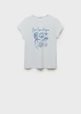 Remera de manga corta color blanco con cuello redondo y diseño recto. Presenta un estampado frontal en tonos azules con ilustraciones de caracoles y la inscripción "Les Coquillages".