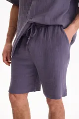 Bermuda negra de muselina con corte baggy, estilo deportivo y cordón ajustable en la cintura.