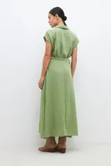Vestido midi color verde pistacho, de corte evasé, con cuello camisero, mangas cortas y cinturón con hebilla redonda.