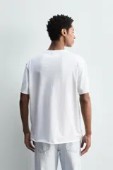 Camiseta de corte relajado confeccionada en algodón ligero, con cuello redondo y mangas cortas con bordes de acabado irregular.