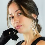 Aros colgantes largos de plata 950, con diseño abstracto de líneas curvas y terminación irregular.