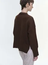 Buzo tejido de corte oversize en color rojo, con cuello redondo, hombros caídos y puños y bajo acanalados.