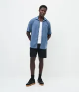 Bermuda masculina de sarga color negro, corte slim fit de estilo sastre con trabillas en la cintura y cierre tradicional.