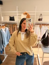 Buzo tipo chomba de corte oversize con diseño a rayas horizontales celestes y blancas. Presenta cuello camisero blanco y un bordado en la espalda con la inscripción República Oriental del Uruguay.
