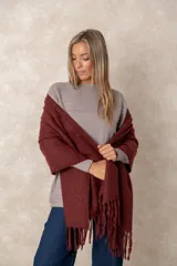 Pashmina de textura suave en color bordó, con diseño rectangular y terminaciones con flecos en los extremos.