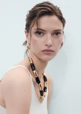 Top de punto fino con cuello en pico y tirantes finos, de diseño entallado y corte corto.