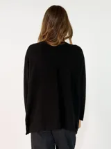 Sweater de punto color verde oliva, con cuello redondo, mangas largas y diseño holgado con costuras visibles en los laterales.