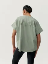 Camiseta blanca de manga corta con corte oversize y cuello redondo. Presenta un sutil estampado en relieve o tono sobre tono en el pecho y la espalda.