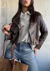 Chaqueta estilo biker de cuero vegano en color chocolate, con cierre frontal asimétrico, solapas clásicas y detalles de costuras visibles.