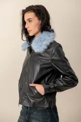 Campera de cuero negro con cuello desmontable de piel sintética en color celeste, cierre frontal y bolsillos laterales.