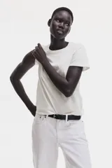 Remera de algodón en punto suave, de color blanco, con cuello redondo ribeteado y mangas cortas.