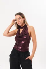 Top halter bordó de tela stretch con acabado satinado y brillo, escote drapeado y cuello alto ajustado.