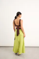 Vestido midi marrón con detalles en rojo, cuello redondo, diseño sin mangas, aberturas cut-out en la cintura y bordados artesanales de flores en contraste.