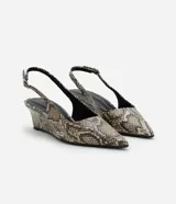 Zapato tipo slingback con estampado de piel de serpiente, puntera fina y taco anabela de 5 cm. Cuenta con tira ajustable en el talón con hebilla metálica.