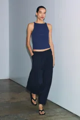 Pantalón de tiro medio confeccionado en mezcla de lyocell, con diseño de pierna ancha y tejido en espiga. Cuenta con cintura elástica ajustable con cordones y bolsillos laterales.