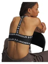 Top deportivo Under Armour modelo HeatGear Mid T Back, color negro con tirantes elásticos y banda inferior elástica con el nombre y logotipo de la marca en blanco. Cuenta con soporte estratégico y diseño de espalda en T.
