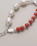 Pulsera de plata 925 con diseño combinado de perlas blancas naturales y piedras esféricas de color rojo, separadas por pequeñas cuentas plateadas.