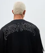 Camisa deportiva de estilo béisbol confeccionada en tejido mesh negro. Presenta cuello en V, cierre frontal con botones a presión, mangas cortas con franjas laterales blancas y bordado con la palabra Breaker y el número 96 en el frente.