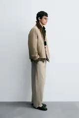 Cazadora de corte relajado confeccionada en tejido técnico con algodón. Presenta cuello de solapa en pana a contraste, cierre frontal con cremallera oculta por solapa con botones a presión, bolsillos de vivo en la cadera y manga larga.