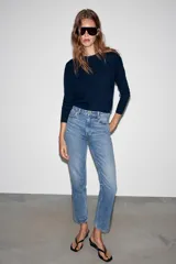 Jeans mom fit de tiro alto y diseño tobillero, confeccionados en denim de lavado medio con cinco bolsillos, trabillas para cinturón y cierre frontal con cremallera y botón metálico.