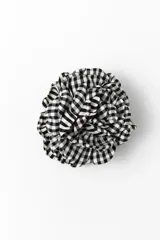Broche con diseño de flor confeccionado en tela con estampado de cuadros vichy en blanco y negro.