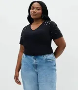Blusa negra de algodón con escote en V y manga corta, decorada con aplicaciones de strass en los hombros.