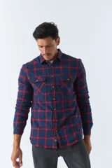 Sobrecamisa de algodón a cuadros color ladrillo, con interior de corderito, cierre con botones, bolsillos tipo cartera y logo en goma. El modelo usa talle M.