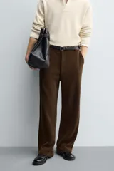 Pantalón de corte wide fit confeccionado en pana de algodón color marrón oscuro. Presenta bolsillos frontales, bolsillos traseros de vivo con botón y cierre frontal con cremallera y botón.
