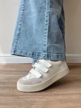 Zapatillas blancas de cuero con detalles en cuero gamuzado color beige en la puntera y ajuste con velcro. Presenta detalle de cuero con estampado reptil en el talón.