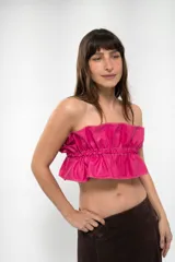 Top strapless de cuero sintético en color fucsia, con diseño fruncido en el centro y costuras a la vista en contraste.
