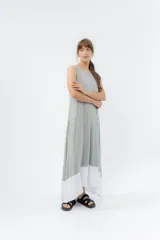 Vestido largo gris con base blanca, de línea amplia y escote redondo.