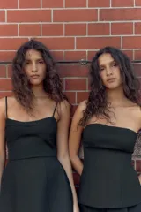 Vestido corto de corte ajustado con escote tipo bustier y tirantes finos. Presenta costuras verticales que definen la silueta y cierre posterior con cremallera oculta.