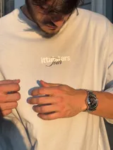 Remera celeste de corte recto con estampado en la espalda que incluye el texto "Itta Stars Tour" y una lista de ciudades: Ibiza, Madrid, Andorra, Barcelona y Formentera.