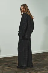 Pantalón de tiro alto con diseño de cuadros, pernera recta y cintura con trabillas. Cuenta con bolsillos laterales, bolsillos de vivo en la parte posterior y cierre frontal con cremallera, botón oculto y gancho metálico.