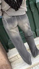 Jean de corte recto y tiro medio, color rosado con efecto acid wash y costuras diagonales en negro.