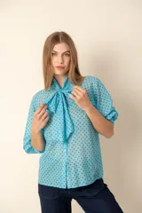Camisa celeste con lunares marrones, cuello con lazo y mangas 3/4 abullonadas.