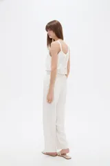 Pantalon de viscosa color blanco, de corte recto, con bolsillos laterales y cintura elástica con cordón ajustable.