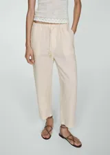 Pantalon de lino de corte jogger, con cintura elastizada y cierre de lazo ajustable. Presenta bolsillos laterales y bolsillos de ribete en la parte posterior.